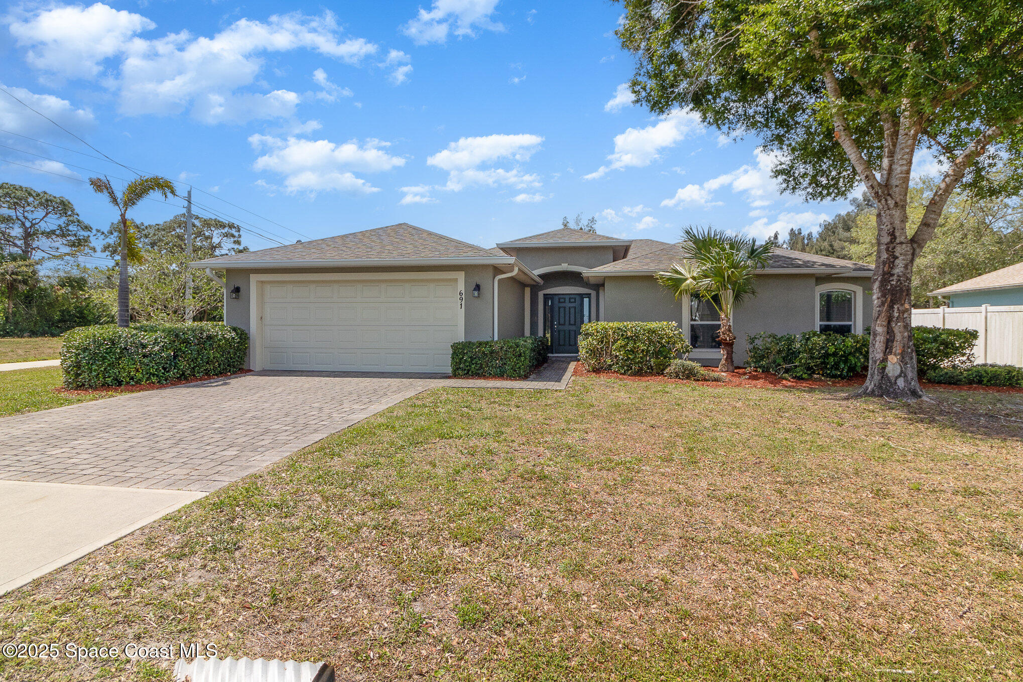 691 Belvedere Road Northwest Palm Bay, FL 32907 - Photo 2 of 26 a front view of a house with a garden