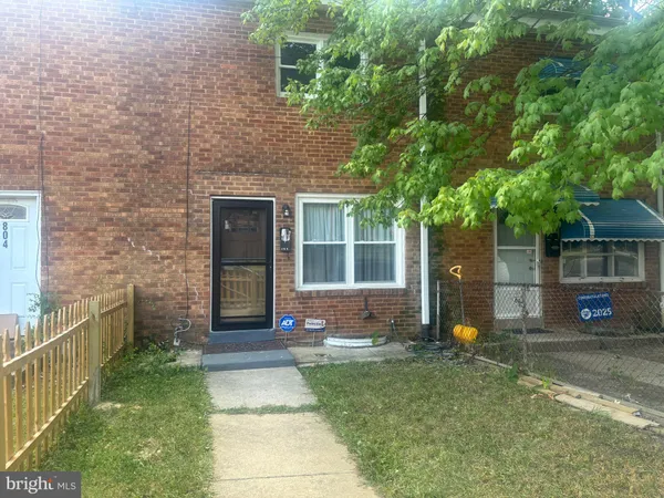 a front view of a house with a yard and potted plants