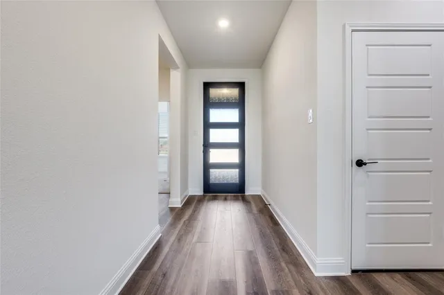 a view of a hallway with wooden floor and closet