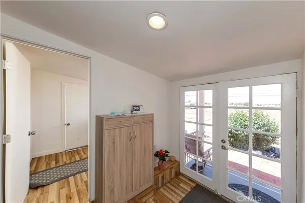 a view of a hallway to a livingroom with wooden floor and windows
