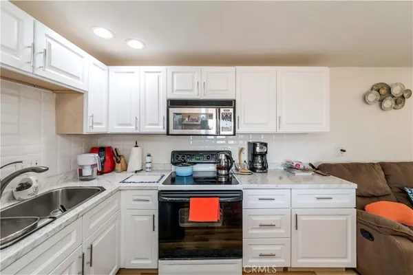 a kitchen with stainless steel appliances granite countertop a stove a sink dishwasher and cabinets with wooden floor