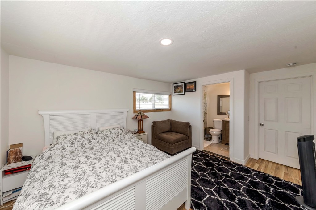 7127 Phelan Road Phelan, CA 92371 - Photo 31 of 44 a bedroom with a bed and wooden floor