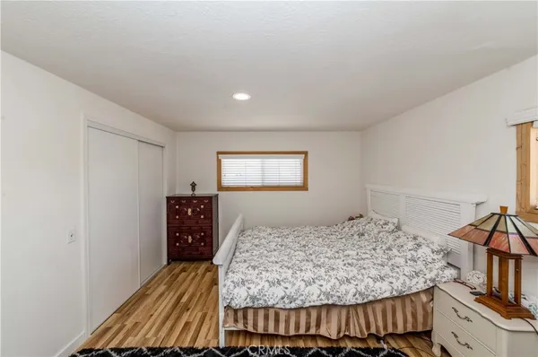 a bedroom with a large bed and a wooden floor