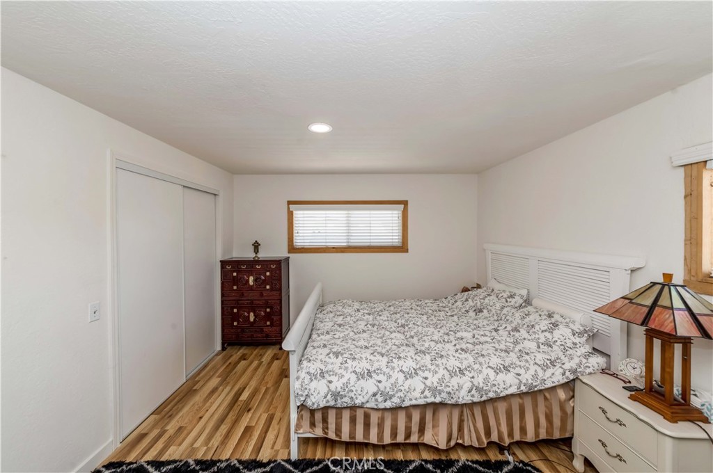 7127 Phelan Road Phelan, CA 92371 - Photo 32 of 44 a bedroom with a large bed and a wooden floor