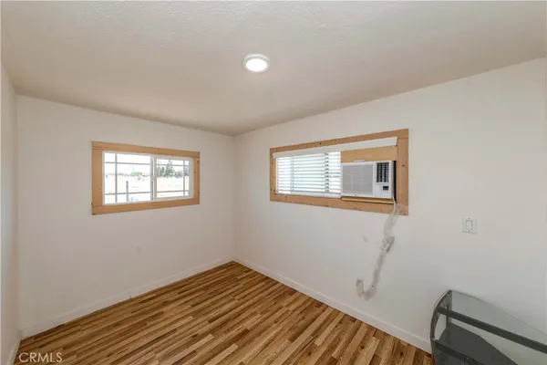 a view of a room with wooden floor and a window