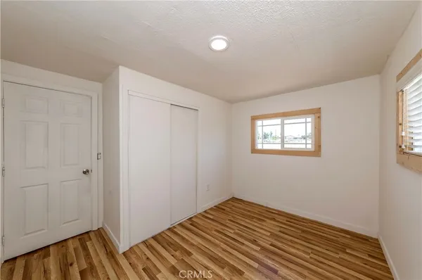 a view of a room with wooden floor and closet area