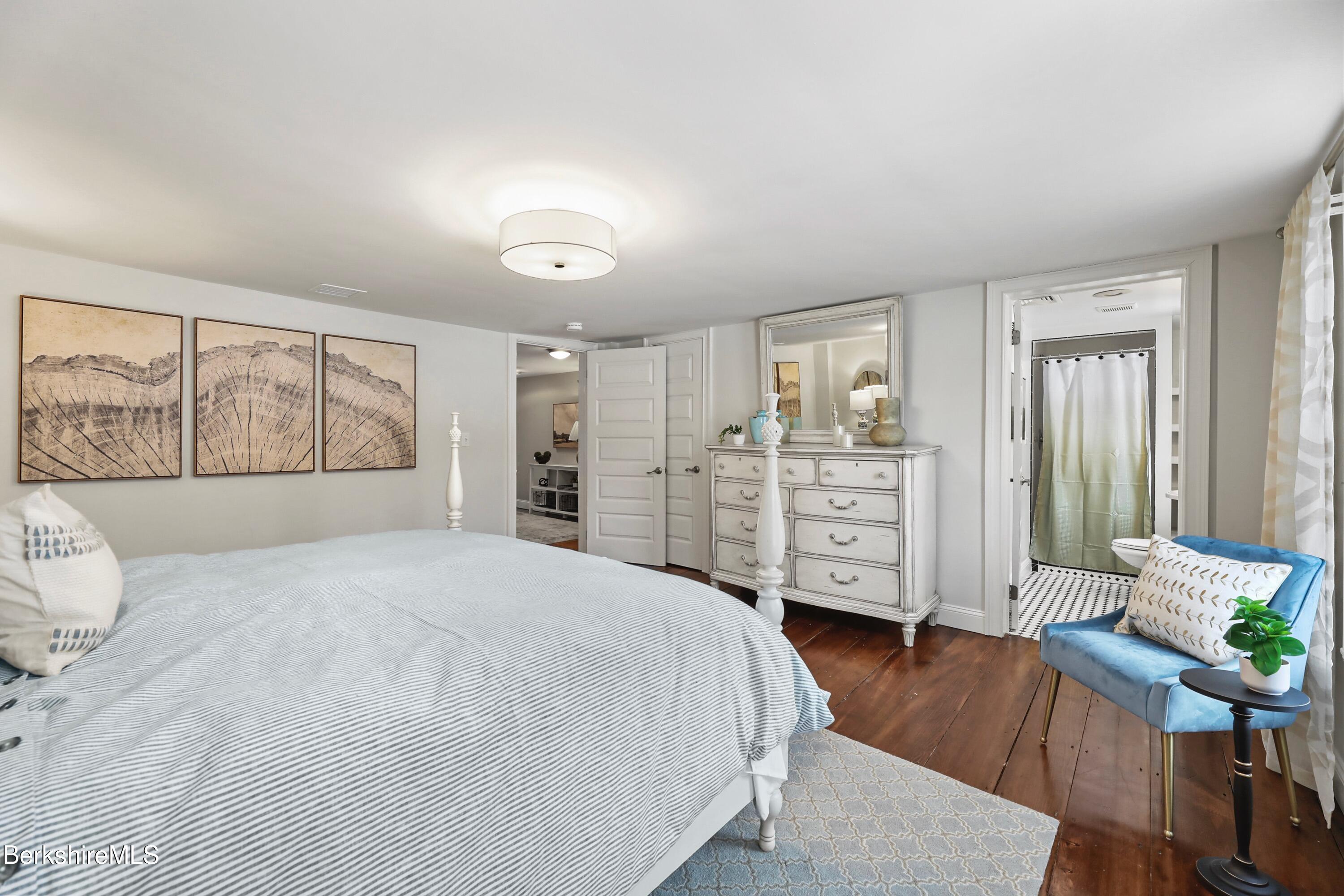 1 Devon Road Stockbridge, MA 01262 - Photo 29 of 58 a bedroom with a large bed and wooden floor