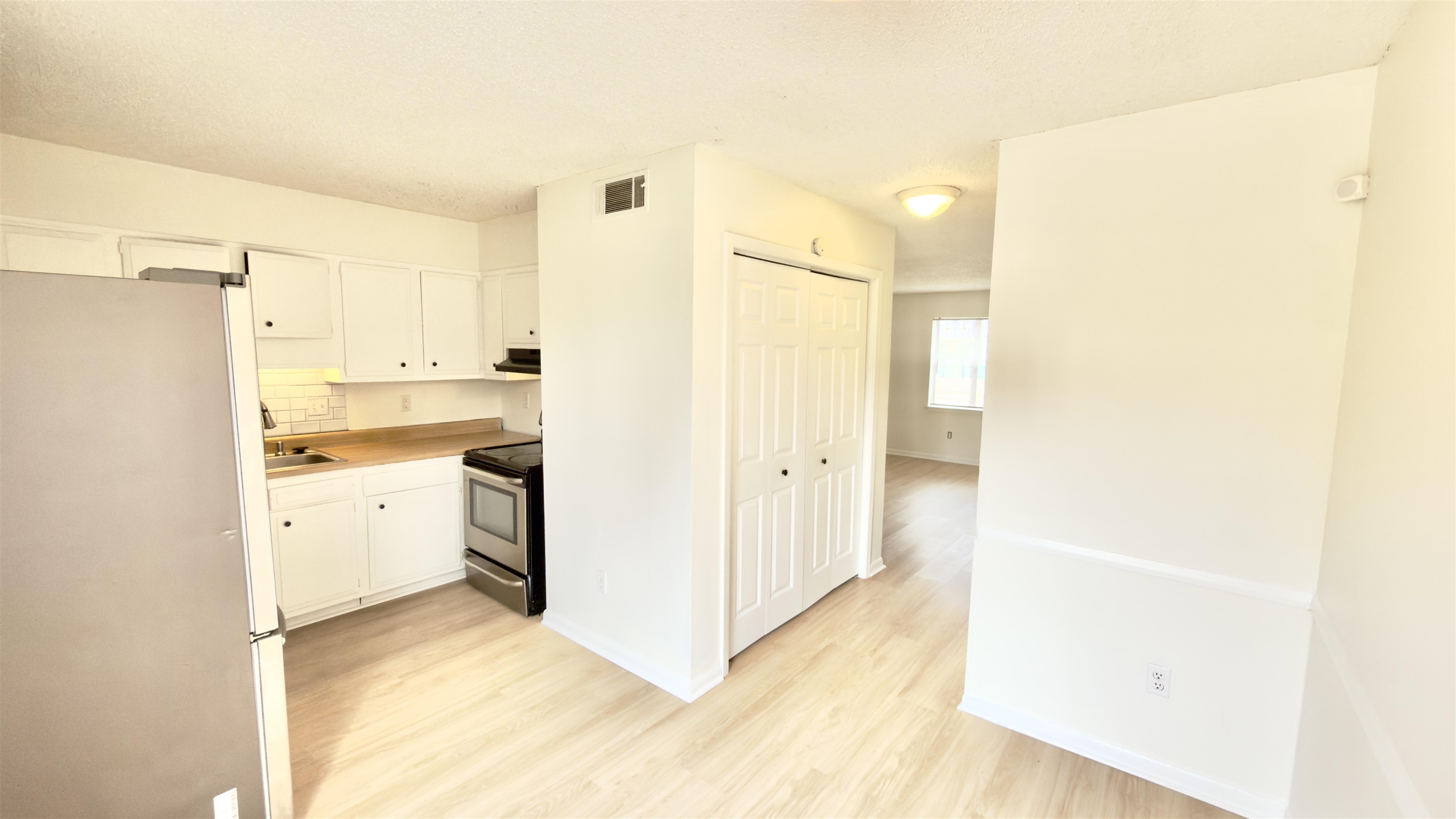 3799 Carnes Avenue Memphis, TN 38111 - Photo 11 of 16 Kitchen featuring stainless steel appliances, light wood-style floors, white cabinets, and light countertops