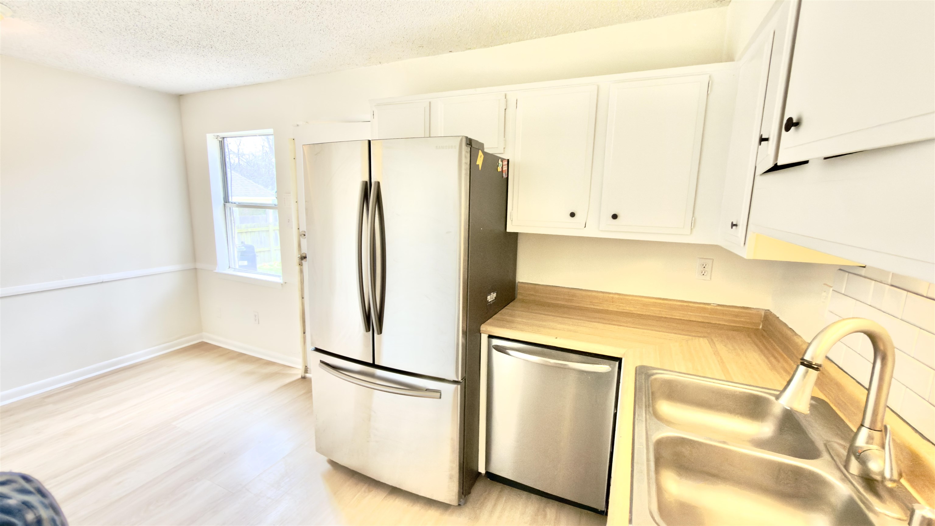3799 Carnes Avenue Memphis, TN 38111 - Photo 12 of 16 Kitchen featuring stainless steel appliances, white cabinets, a textured ceiling, and light wood-type flooring