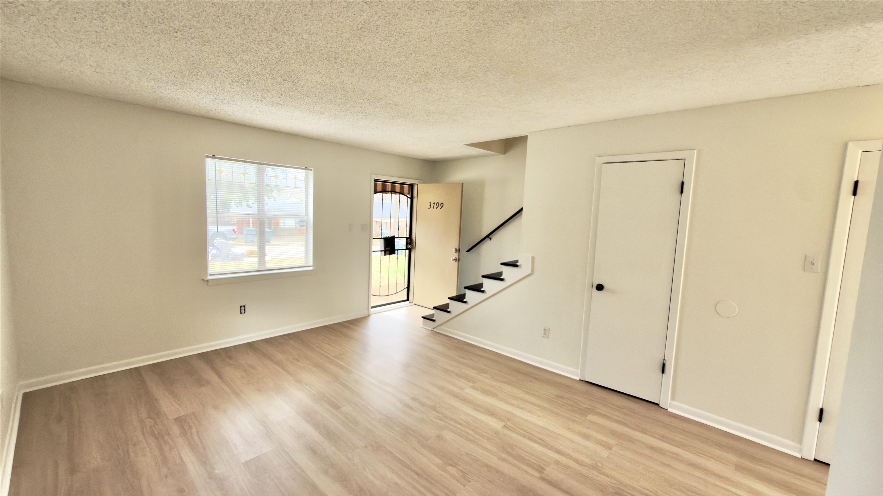 3799 Carnes Avenue Memphis, TN 38111 - Photo 3 of 16 a view of an empty room with wooden floor and a window