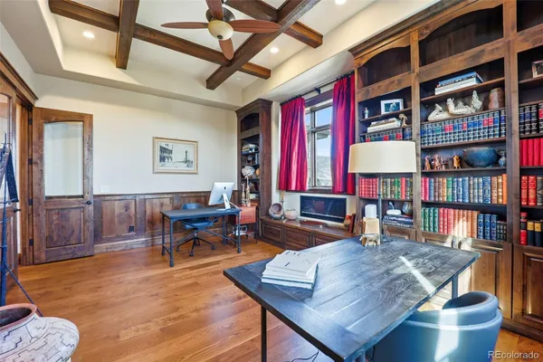 a living room with furniture a bookshelf and a window
