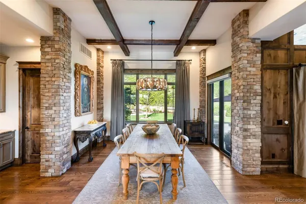 a dining room with wooden floor and a chandelier