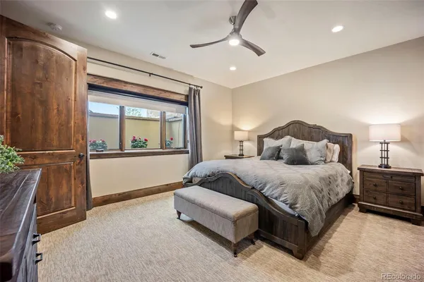a spacious bedroom with a bed and a dresser with the shower