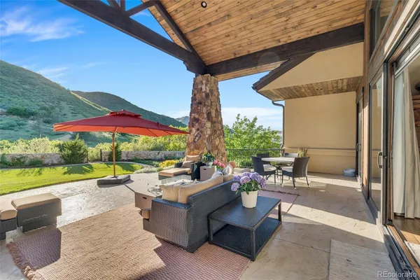 a view of a patio with a table and chairs under an umbrella