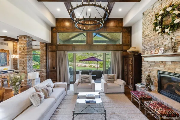 a living room with furniture a fireplace and a chandelier