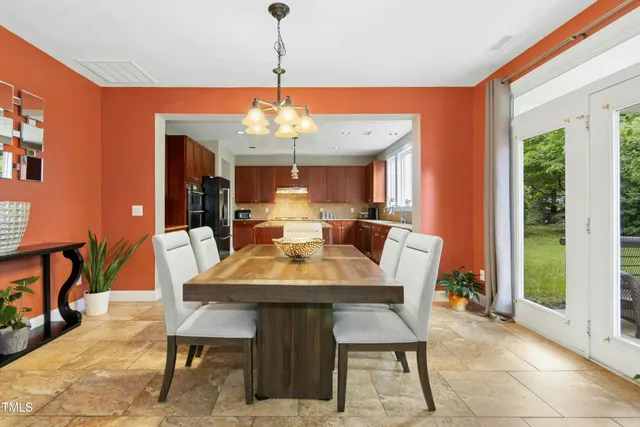 a kitchen with stainless steel appliances kitchen island granite countertop a refrigerator a stove and a sink with wooden floor