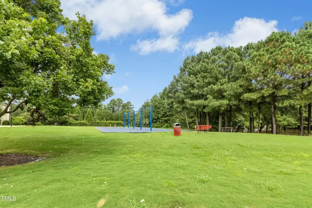 a view of a tennis ground with large trees