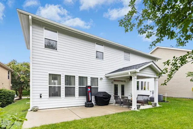 a view of a white building with a large window and large tree