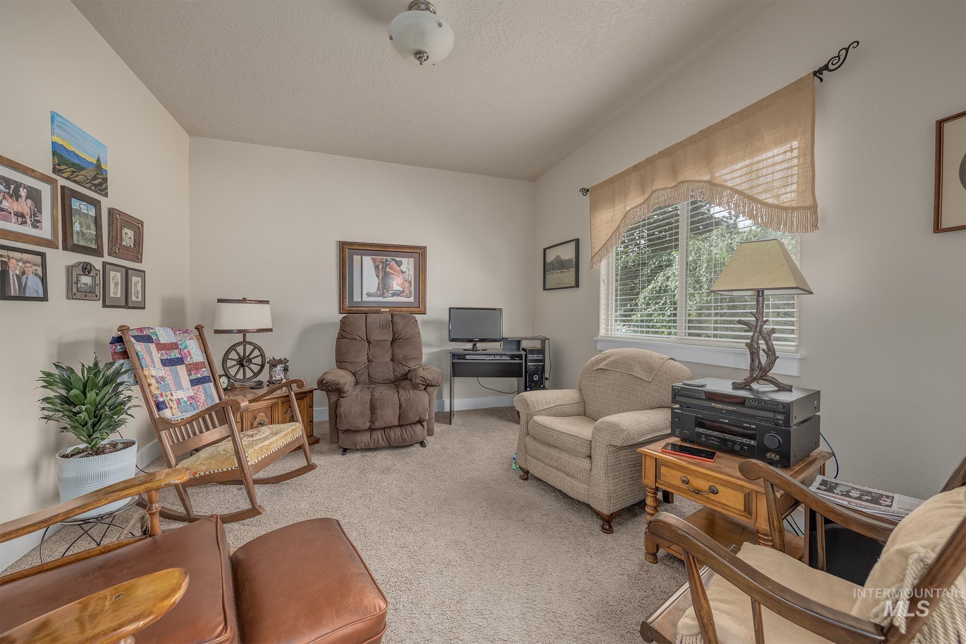 420 West Indianhead Road Weiser, ID 83672 - Photo 11 of 40 Versatile interior space featuring vaulted ceilings, neutral wall tones, and plush carpet flooring