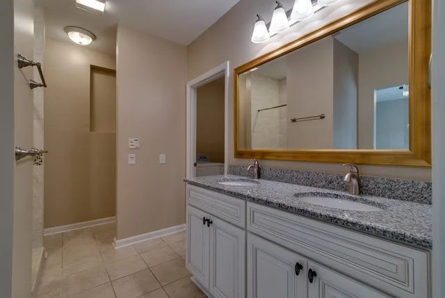 a bathroom with a granite countertop sink and a mirror