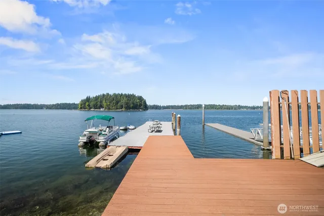 a view of a lake with couches chairs and wooden floor