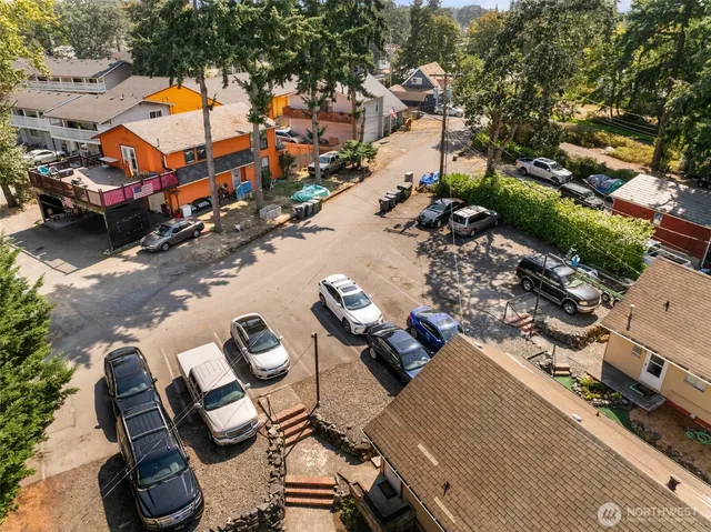 an aerial view of city and lake with trees all around