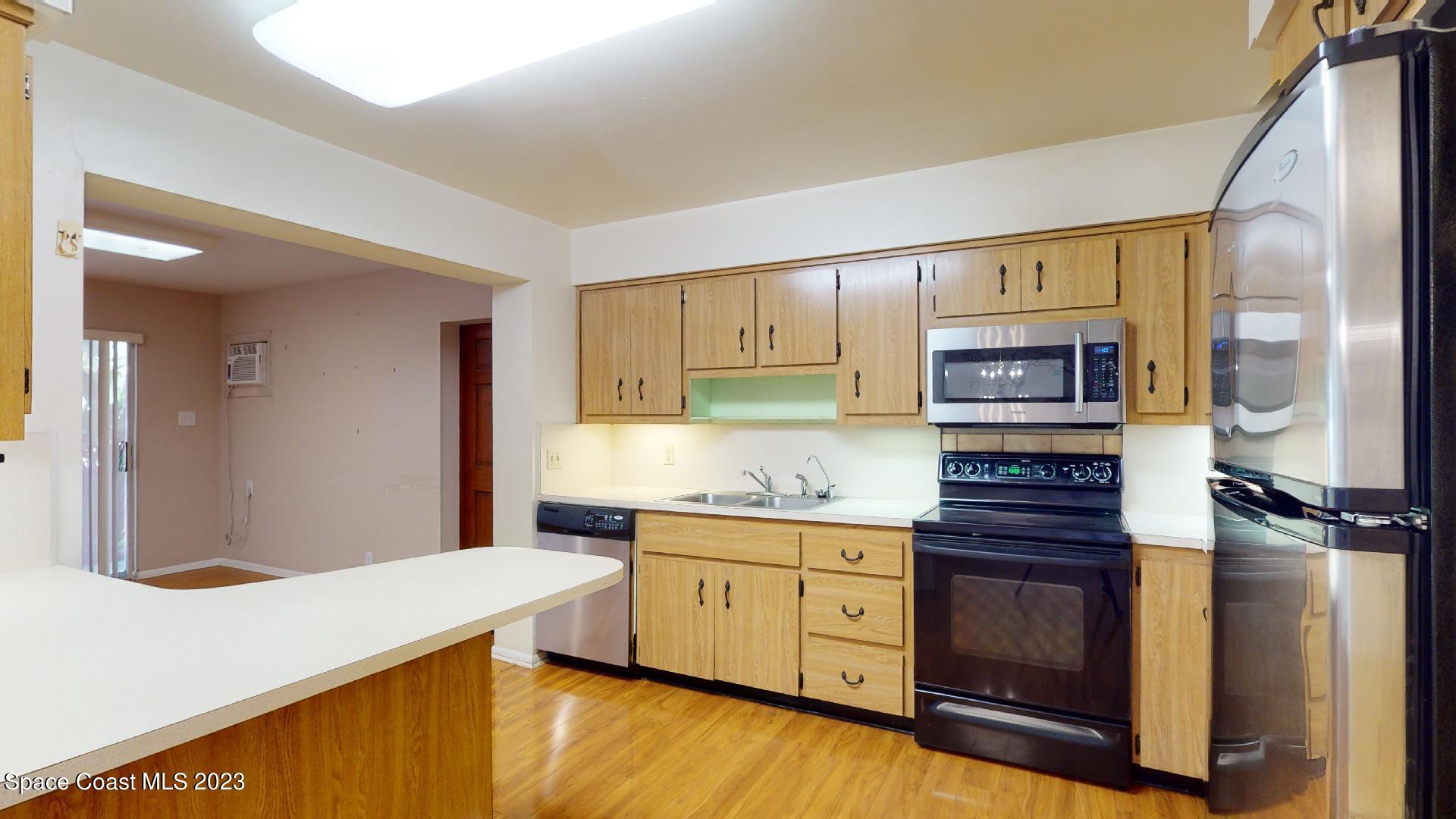 204 South Riverside Drive Indialantic, FL 32903 - Photo 7 of 24 a kitchen with stainless steel appliances granite countertop a stove and a refrigerator