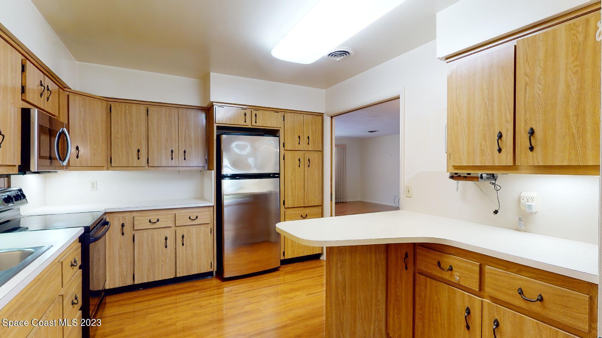 204 South Riverside Drive Indialantic, FL 32903 - Photo 9 of 24 a kitchen with stainless steel appliances a sink and a refrigerator