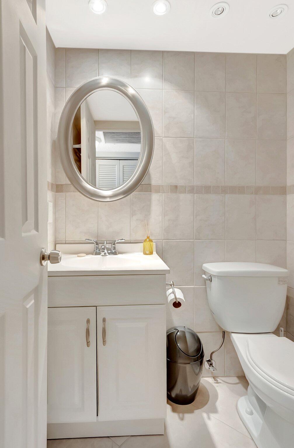 2043 Cambridge C Deerfield Beach, FL 33442 - Photo 12 of 75 a bathroom with a toilet a sink and a mirror