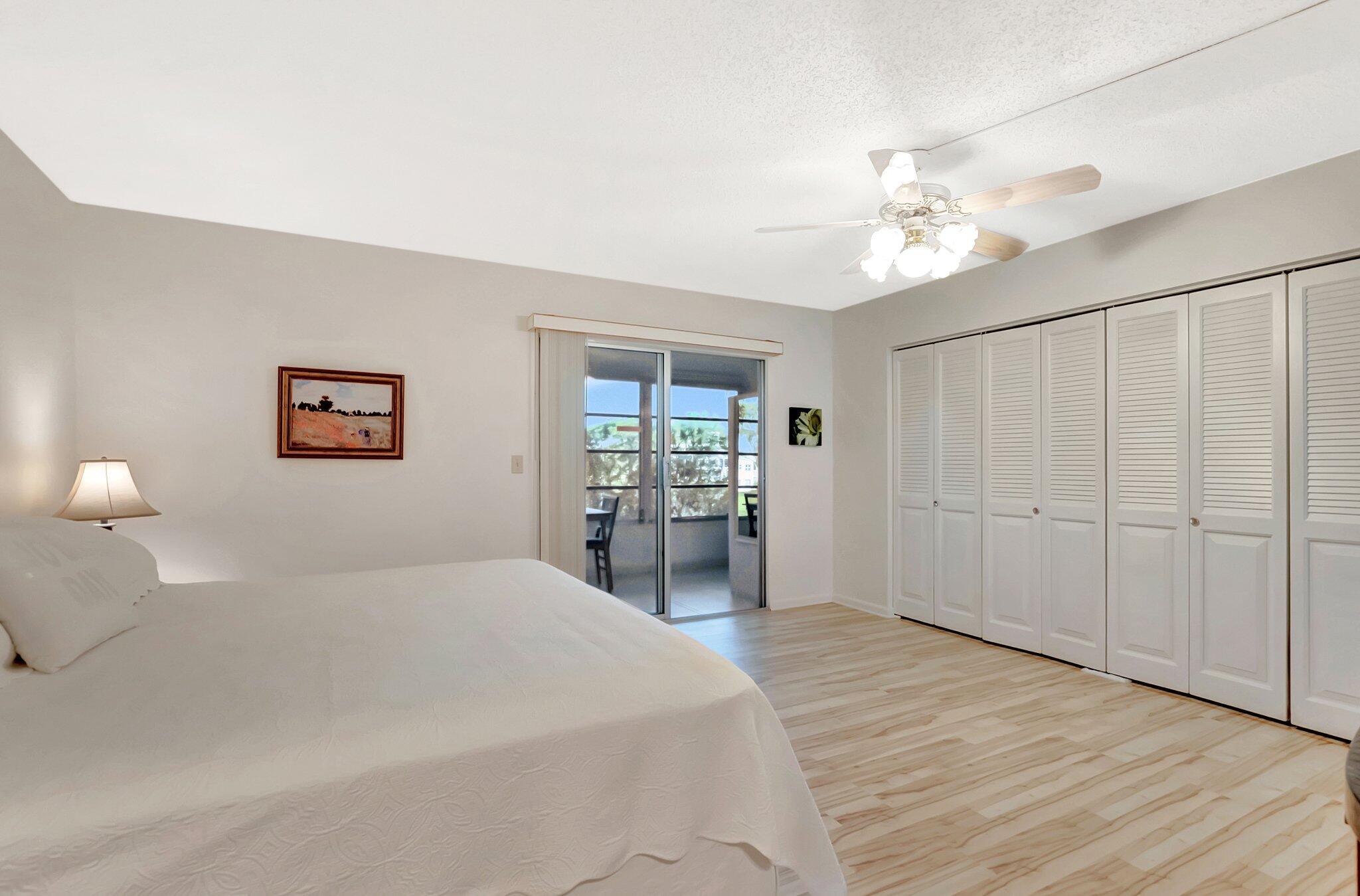 2043 Cambridge C Deerfield Beach, FL 33442 - Photo 14 of 75 a bedroom with a large bed and a chandelier