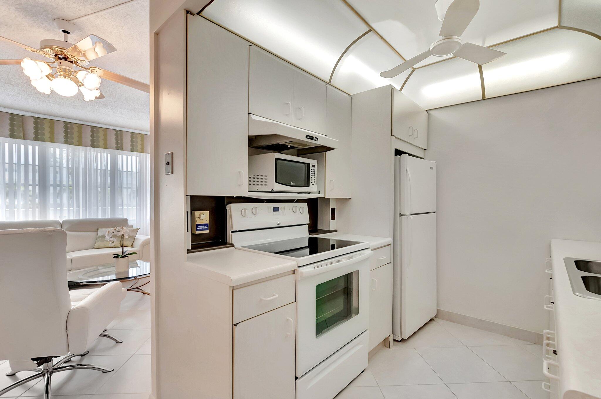 2043 Cambridge C Deerfield Beach, FL 33442 - Photo 10 of 75 a kitchen with a stove cabinets and a refrigerator
