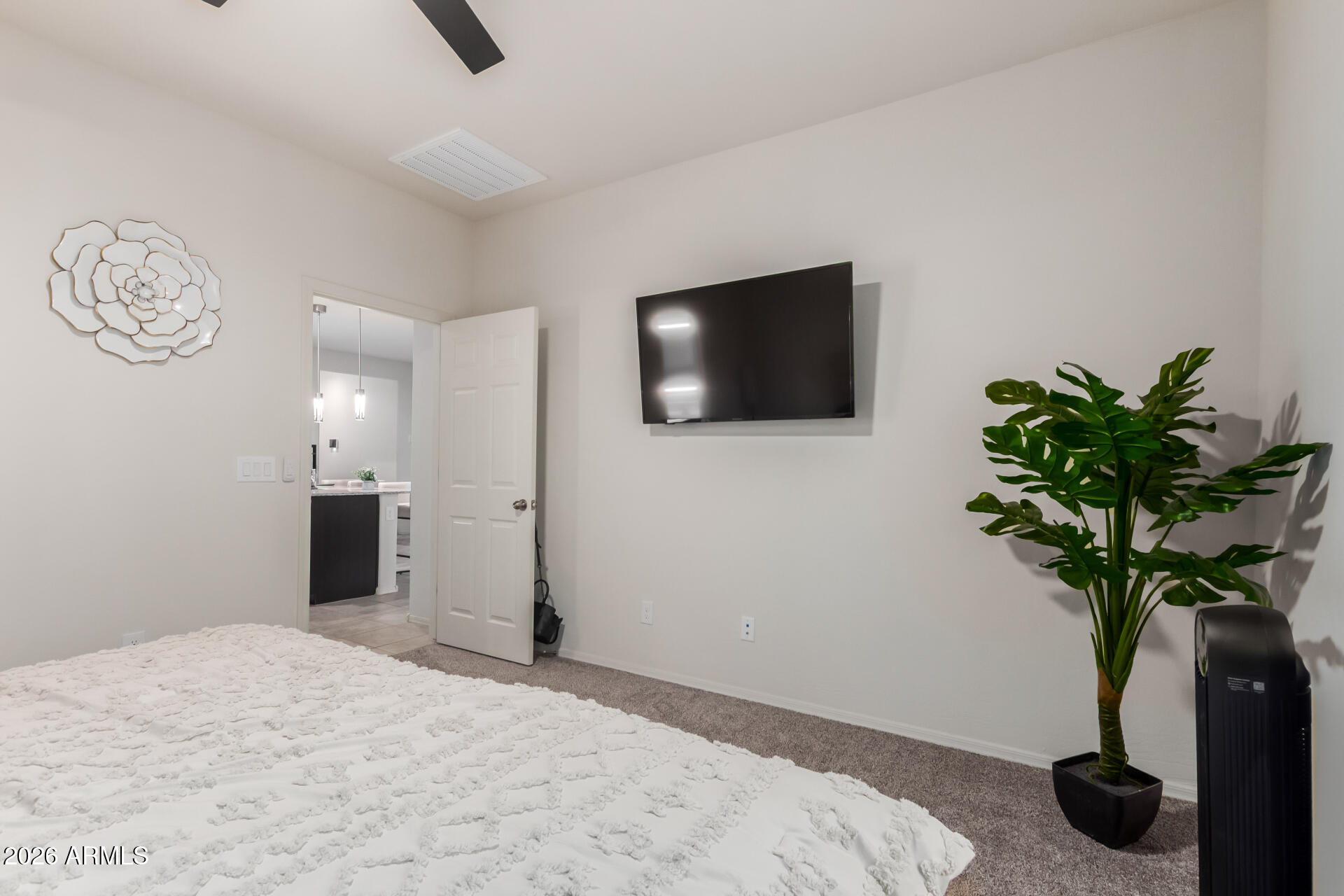 11214 West Bloch Road Tolleson, AZ 85353 - Photo 14 of 24 a bedroom with a bed and a potted plant
