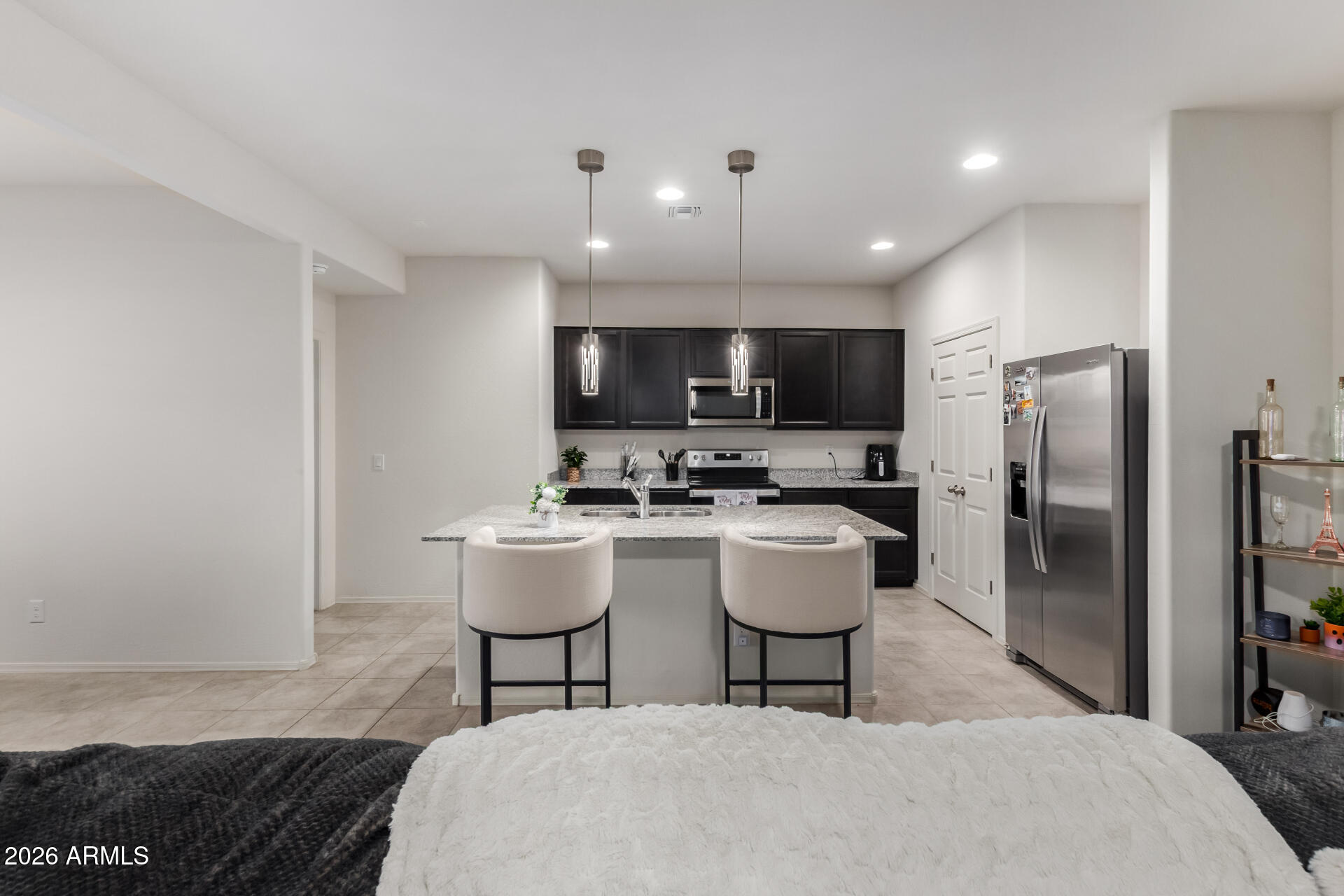 11214 West Bloch Road Tolleson, AZ 85353 - Photo 7 of 24 a kitchen with a sink stainless steel appliances and refrigerator