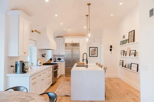 a large white kitchen with cabinets