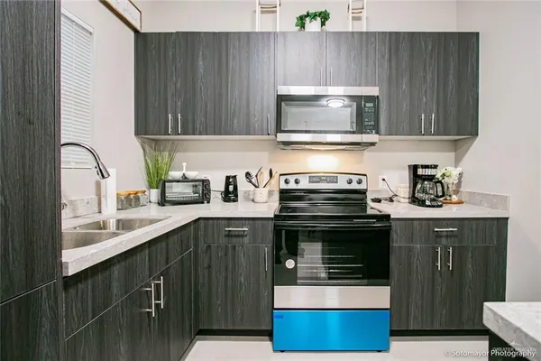 a kitchen with stainless steel appliances a stove and a sink