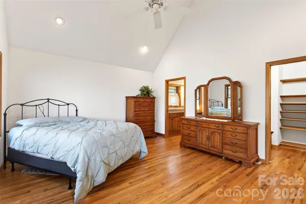 a bedroom with a large bed and wooden floor