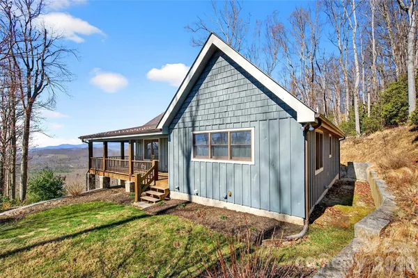 a view of backyard with deck area and wooden fence