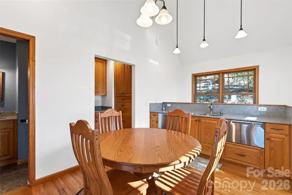 a view of a dining room with furniture a chandelier and wooden floor