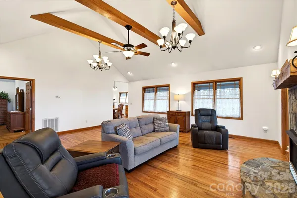 a living room with furniture a chandelier and a flat screen tv