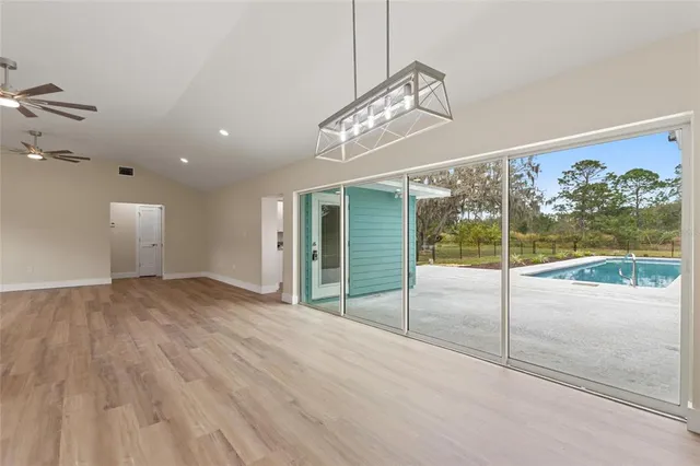 a view of a livingroom with wooden floor and a chandelier