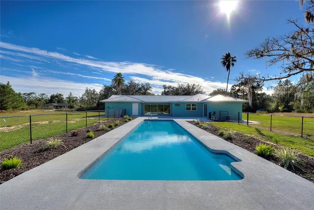 a swimming pool with outdoor seating and yard