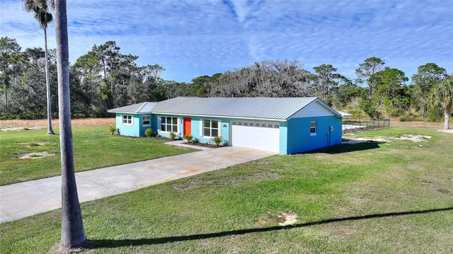 a view of a lush green forest with a building in the background