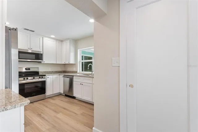 a kitchen with stainless steel appliances granite countertop a stove top oven a sink and dishwasher