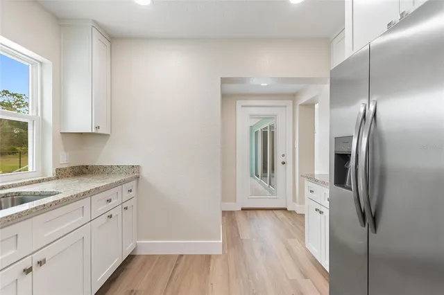 a kitchen with a refrigerator sink and cabinets