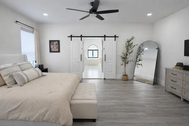 a spacious bedroom with a bed and a dresser