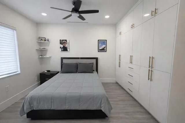 a bedroom with a bed and painting on the wall