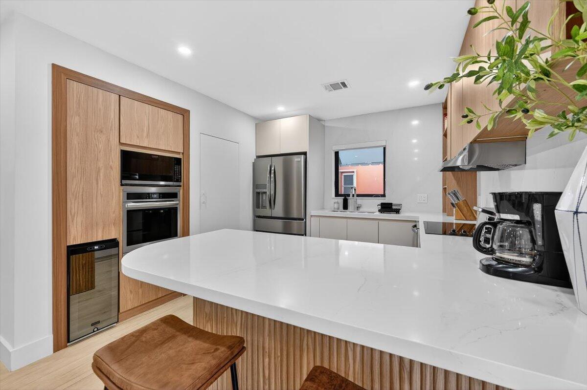 2601 Southwest 26th Lane Miami, FL 33133 - Photo 11 of 34 a large living room with stainless steel appliances furniture a chandelier and a view of kitchen