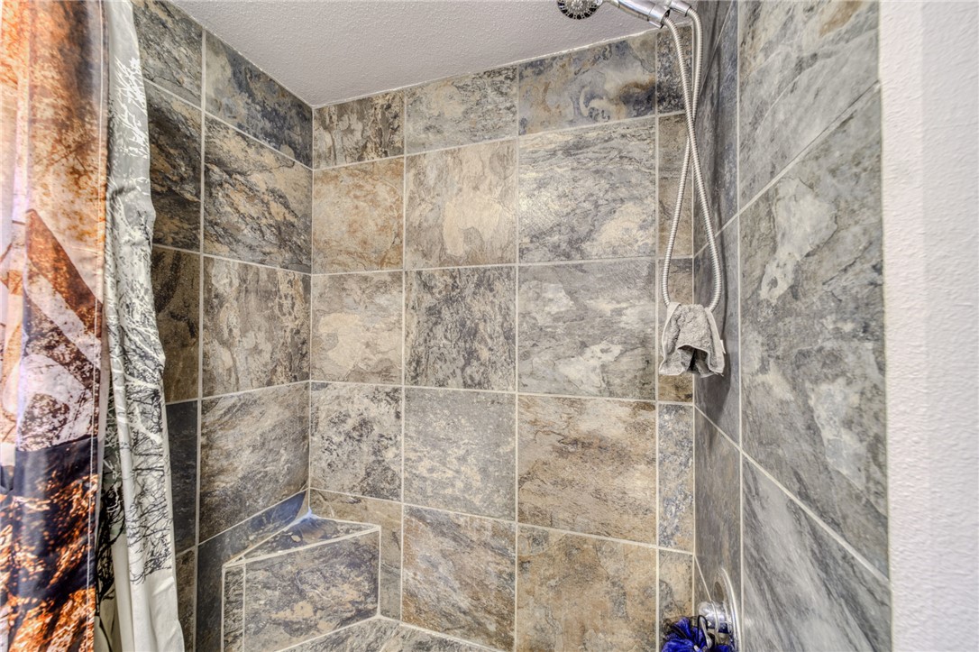 10531 Star Road Mohave Valley, AZ 86440 - Photo 13 of 34 Bathroom view of a tile shower and a textured ceiling