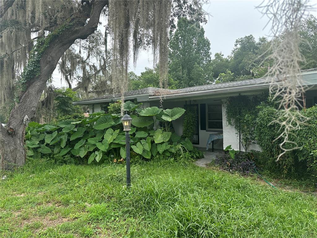 a backyard of a house with table and chairs and potted plants