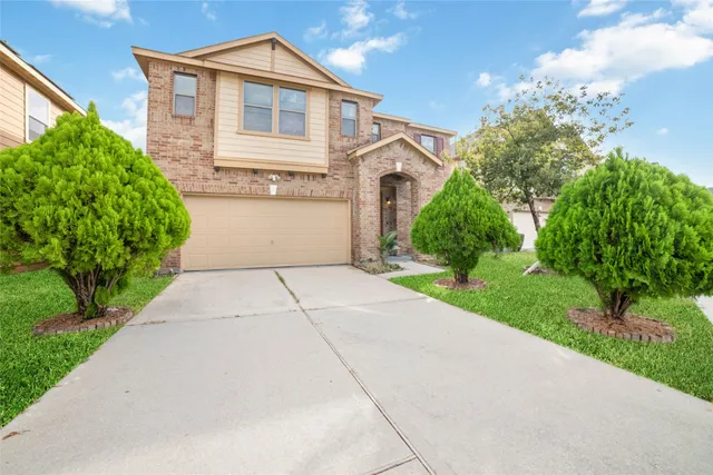 a front view of a house with a yard and potted plants
